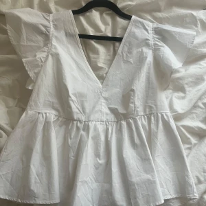 Vit blus med volang och v-ringning - Supersöt blus från Carin Wester som tyvärr inte kommer till användning🥰