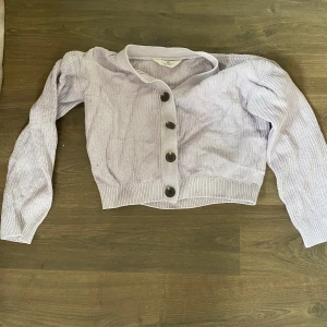 Ljuslila stickad kofta med knappar - Superfin ljuslila stickad kofta från H&M med stora knappar framtill. Croppad modell med långa ärmar och ribbade muddar. Perfekt att slänga över en topp för en chill look. Snygg och enkel att matcha med jeans eller kjol. Den ser bättre ut när den inte är skrynklig och så är den mer lila i verkligheten.🌸