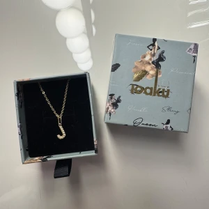 Ioaku halsband - Ett guld Ioaku halsband med bokstaven J. Det är ingraverade stenar i J:et. Halsbandet är i bra skick, jag har köpt ett annat halsband och därför kommer inte detta till användning längre. Hör gärna av dig vid frågor💗💗