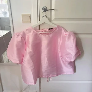 Rosa topp med puffärmar - Supersöt ljusrosa topp från Boohoo med puffiga korta ärmar och snygga knytband i ryggen