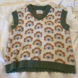 Blommig stickad väst från Zara - Superfin stickad väst från Zara med blommigt mönster. Storlek 152 men skulle säga att det är som en S