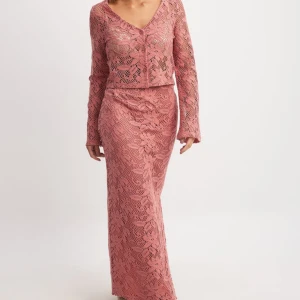 Rosa långklänning i spets - Set i rosa spets med blommigt mönster. Perfekt för dig som vill sticka ut med en romantisk och trendig look. Helt ny med prislapp.