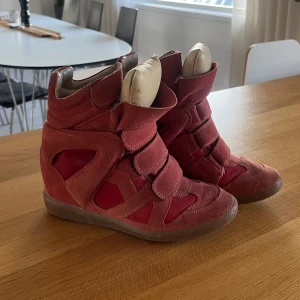 Röda Isabel Marant Bekett sneakers - Säljer mina älskade, feta Isabel Marant bekett sneakers i jättefint skick! Jag köpte dom på Sellpy där de är äkthetstestade, och kan självklart visa orderbeviset därifrån. Säljes för 3000 men är oxå  öppen för ett byte till ett par Isabel Marant kilklackar (Bekett eller Bobby) i beiget eller brunt, alternativt ett par vita/biega adidas sambas!! Kom med förslag⭐️⭐️😽. (Säljer massor av feta jeans nu så ta en titt i min profil!!)