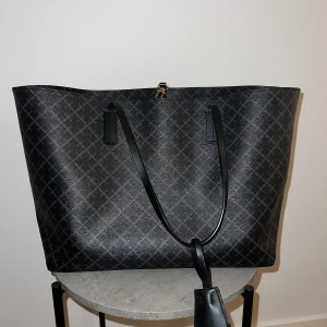 Abigail tote By Malene Birger - Supergin väska från By Malene Birger i färgen charcoal. Den ser nästan ny ut förutom lite smuts (och damm) inne i väskan samt små slitningar på 2 av remmarnas sidor, dock är inget av dem  märkbara mer än vid väldigt nära inspektion. Nypris 2795kr. Pris kan diskuteras vid snabb affär.