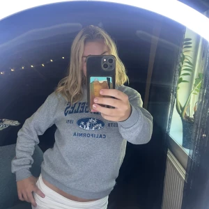 Grå supermysig tröja med blått tryck - Säljer en grå sweatshirt med blått tryck framtill där det står 'CALIFORNIA'. Superskönt material i både insidan och utsidan av tröjan! 💓