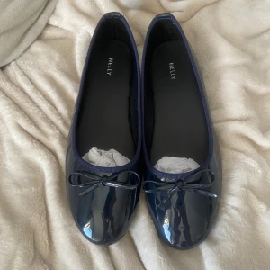 Mörkblå ballerinaskor från Nelly - Snygga mörkblå ballerinaskor från Nelly med glansig finish och söt rosett framtill. 💕💕💕Helt nya, säljer då de va för stora 
