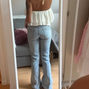 Ljusblå bootcut jeans från Zara - Säljer ett par ljusblå jeans från Zara med bootcut passform. Jeansen har klassisk femficksdesign, normal midja och är tillverkade i bomull. Perfekta för dig som gillar en retro vibe och vill ha ett par snygga jeans med lite utsvängda ben. (Storleken är något liten) 