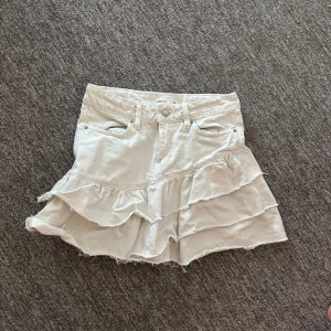 Vit volangkjol i jeans - Supersöt vit kortkjol som är använd ett fåtalgånger. 