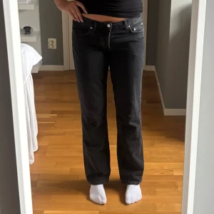 Svarta jeans från Lager157 - Säljer ett par svarta raka jeans från Lager157 med klassisk femficksdesign och knappgylf. Modellen heter Icon. Jeansen har en lowwaist passform och är tillverkade i mjukt bomullstyg. Perfekta för en chill och stilren look.