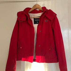 Vårjacka - Säljer denna assnygga jacka från Hollister i en fin röd färg. Från deras ”All-Weather” serie, superbra kvalitet med stor huva vilket jag tycker gör den så snygg och så har den flis på insidan. Hel och ren! Endast använd 1 säsong.🥰