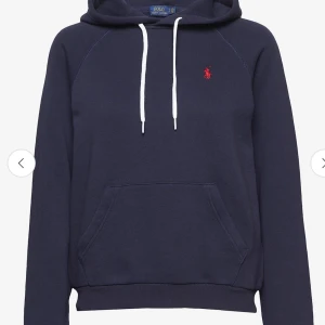 Mörkblå hoodie från Ralph Lauren - Säljer en snygg mörkblå hoodie från Ralph Lauren med det klassiska röda logotypen på bröstet. Tröjan har en känguruficka och vita dragsnören i huvan. Perfekt för en avslappnad stil!