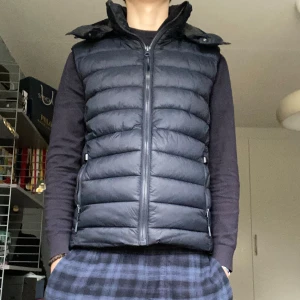 Svart dunväst från Superdry - Snygg mörnblå dunväst från Superdry med dragkedja. Perfekt för lager-på-lager under kyliga höst dagar. Västen passar perfekt för en stilren look🔋🙌 hör gärna av er vid minsta fundering😄