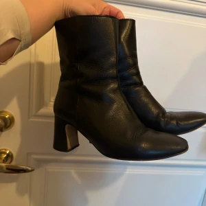 Svarta skinnstövletter - Snygga svarta stövletter i äkta skinn med klack och spetsig tå. Perfekta för en stilren look.