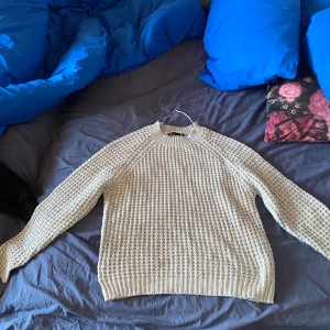 Grå stickad tröja - Säljer en mysig grå stickad tröja med ett klassiskt mönster. Tröjan har långa ärmar och ribbstickade muddar vid ärmslut och nederkant. Perfekt för kyliga dagar! Har använt den typ 10 gånger jätte fin tröja som är väldigt mysig.