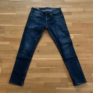 Mörkblå Dondup George  - Säljer ett par mörkblåa dondup jeans med feta slitningar. Jeansen passar dig som är mellan 170-175cm
