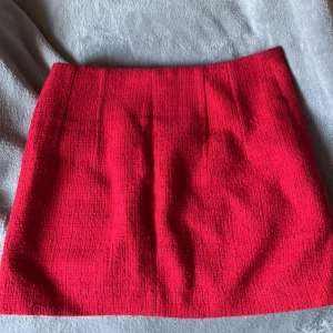 Röd kjol från MNG - Snygg röd kjol från MNG. Väldigt fin om man vill klä upp sig. Kjolen har en klassisk och stilren design som passar perfekt för olika tillfällen. Den är kort och har en rak passform som ger en modern look.