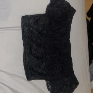 Svart spets tubtopp från Shein - Säljer en elegant svart spets tubtopp från Shein. Toppen är ärmlös och har en vacker spetsdesign som ger en romantisk känsla. Perfekt för att styla med olika outfits för en chic look.