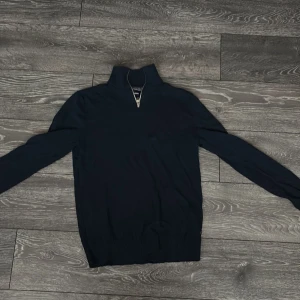 Svart halfzip från Jack & Jones - Säljer en stilren svart tröja från Jack & Jones med dragkedja vid halsen. Perfekt för en avslappnad look. Tröjan har långa ärmar och en bekväm passform.