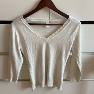 Vit trekvartsärmad v-ringad tröja - Säljer en vit tröja från H&M med v-ringning och trekvartsärmar. Tröjan har ribbade detaljer vid ärmslut och nederkant. Sitter super gulligt 