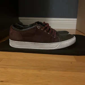 Sjukt feta vinröda sneakers från LANVIN! - Snygga vinröda sneakers från Lanvin med vita sulor och snörning. Skorna har en stilren design med en mörkare tåsektion och är perfekta för en avslappnad look. Prefekt sko nu för sommaren.