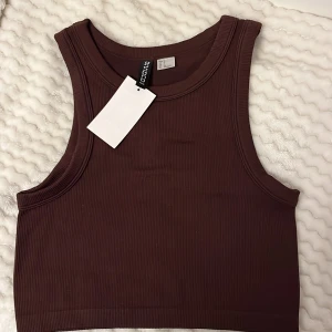 Helt ny Brun ribbad linnetopp från H&M🍂 - Säljer en snygg brun ribbad linnetopp från Divided.🦌