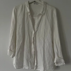 Vit linneskjorta med knappar - GARDEROBSRENSNING! Köpt i större storlek för en oversized look! PERFEKT som strand skjorta 