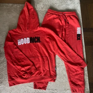 Röda mjukisbyxor från Hoodrich - Röda mjukisbyxor från Hoodrich med broderad logga i vitt och svart på benet. Byxorna har resår i midjan med snörning och är gjorda i mjuk bomullsmix med fleece på insidan. Perfekta för chill eller streetwear-stil. Priser kan diskuteras