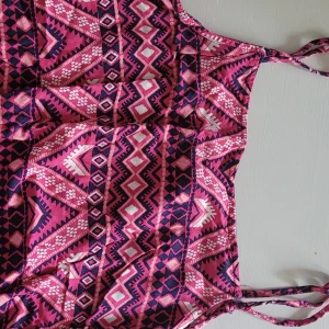 Mönstrad rosa linne H&M Divided - Säljer ett färgglatt linne från H&M Divided i storlek 38. Linnet har tunna axelband och ett coolt geometriskt mönster i rosa, mörkblått och vitt. Perfekt för varma dagar och ger en riktigt skön sommarkänsla.