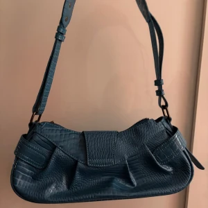 Blågrön handväska - Blågrön handväska med korthållare som man kan ta av, från Urban Outfitters. Köpt för ca 1 år sedan men helt oanvänd då jag har många andra väskor. Nypris ca 200-300kr minns inte exakt!🤗💗