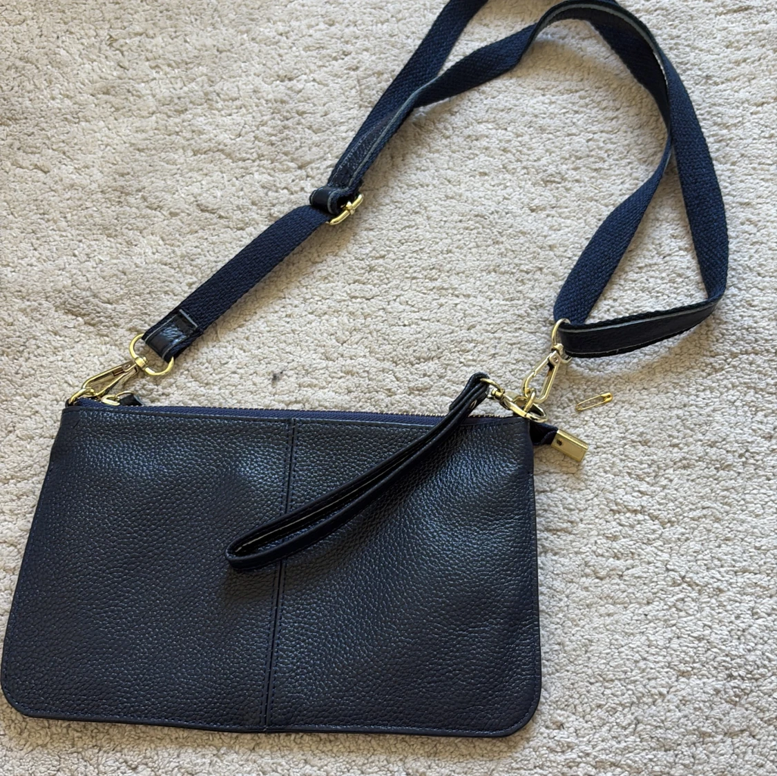 Mörkblå axelväska i skinn med guldiga detaljer