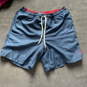 Hej jag säljer ett par Ralph lauren shorts/badshorts i storlek small-medium - Hej jag säljer ett par mörk blåa Ralph lauren short/badshorts i storlek small-medium dom är försmå så jag säljer dom