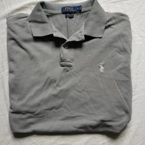Ralph Lauren piké  - Tjo gubbar! En Ralph Lauren piké i fin grå färg, storlek L har några små på ryggen men annars perfekt. Passar perfekt till just dig😉. Kolla gärna profilen för mer Ralph Lauren kläder och följ gärna också 😉❤️. Ha de göttttttt!!