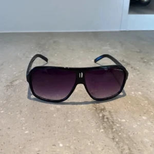 Svarta Carrera solglasögon  - Snygga svarta solglasögon från Carrera, nypris ligger runt 800-1000kr men eftersom min semester är över vill jag bara bli av med dem, förhoppningsvis till någon annan som kan ha nytta av dem!