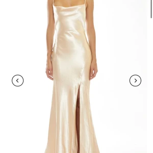 Champagnefärgad långklänning i satin - Champagne färgad balklänning i satin från True Decadence. Använd en gång. Köpt för 1500. Den är uppsydd och passar i längden för någon som är ungefär 173 cm