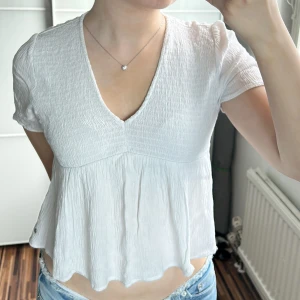 Vit blus med v-ringning och kort ärm - Supersöt vit blus med v-ringning. Köpt i spanien!