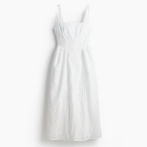 Vit broderie anglaise långklänning - Superfin vit långklänning med broderade detaljer och hålmönster. Klänningen har breda axelband, markerad midja och en lätt utställd kjol. 