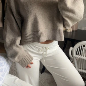 Beige croppad stickad polotröja - Säljer en beige croppad stickad polotröja med bred ribbad mudd i nederkant och ärmslut. Tröjan har en hög krage och en smickrande loose passform med långa ärmar. Storlek S/M, men skulle säga att den passar de flesta!