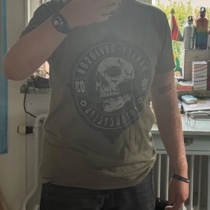 Olivgrön Harley-Davidson t-shirt med döskalle - Snygg olivgrön t-shirt från Harley-Davidson med stort tryck av döskalle på bröstet. Rund hals och korta ärmar, tillverkad i mjuk bomull. 