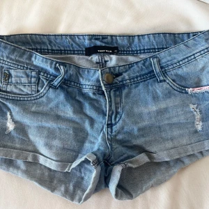 Blå jeansshorts - Säljer ett par snygga lågmidjade jeansshorts från Tally Weijl med slitna detaljer. Knappt använd då de är för stora för mig.