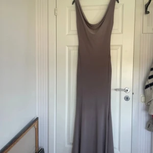 Grå långklänning från Design by si - Fin grå långklänning från Design by si som aldrig har används