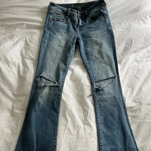 Bootcut jeans från American Eagle - Jättesnygga lågmidjade bootcut jeans från american eagle med två hål på knäna💕 mått kolla bilderna💕