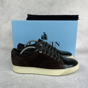 Lanvin DBB1 cap toe sneaker - – Condition: 8/10  - Size: 41/UK7  – What is included: Dustbag  – Retail price: 6000 + SEK  Please note that Lanvins fit big and our recommendation is to go one size down