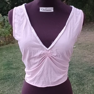 Ljusrosa croptop - Omsydd ljusrosa croptop från Cafécrème med v-ringning och spetskant. Toppen har öppen rygg med knytning i midjan och även knytning på insidan vid urringningen🌸🪸💗 Använd men skönt tyg. Det är bara att skriva om man har frågor!😊💖