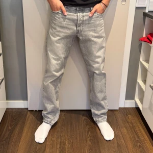 Grå loose jeans  - Säljer ett par grå jeans ifrån Jack and Jones som inte kommer till användning. Jeansen har en loose passform och är något lösare än regular. Storlek 32/34. Skriv vid frågor.