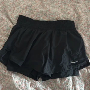 Svarta träningsshorts från Nike - Säljer ett par svarta träningsshorts från Nike med elastisk midja och klassisk logga på benet. Aldrig använda.