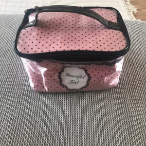 Rosa prickig neccisär Beautiful Girl - Söt rosa necessär med svarta prickar och svart handtag. Väskan har ett tryck med texten 'Beautiful Girl' på framsidan och stängs med dragkedja. Insidan är ljusrosa och har fack för småsaker. Perfekt för smink, kommer inte till användning💗