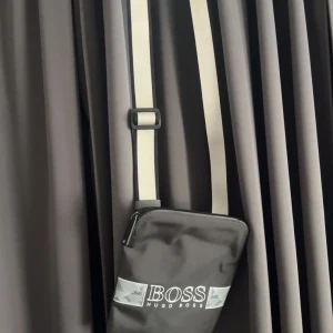 Hugo boss väska - Grå Hugo boss axelremsväska. Den är i fint skick och går ej att få tag på längre.