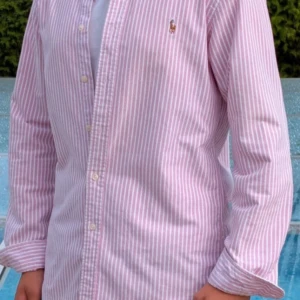 Rosa randig skjorta från Ralph Lauren - Rosa randig Ralph Lauren skjorta👔  Storlek M ✅  Nypris ca 1800kr 💵  Nästan helt ny 🆕  Pris går att diskutera 🤝 Hör av er vid frågor eller fler bilder :)