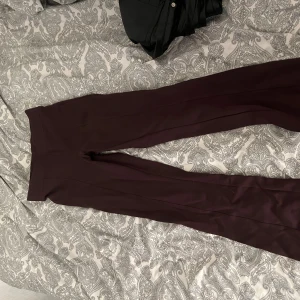 Bruna vida byxor med hög midja - Snygga bruna byxor med hög midja och vida ben. Byxorna har en stilren look och är perfekta för dig som gillar en trendig och bekväm stil. Materialet känns mjukt och följsamt, vilket gör dem sköna att bära hela dagen.