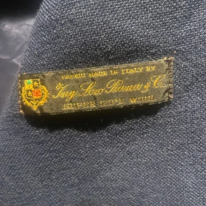 Loro Piana X J.lindberg Kavaj  - Nypris 8000kr, Mörkblå kavaj tillverkad i exklusiv super 120's ull från italienska Ing. Loro Piana. Klassisk modell med två framfickor med lock, bröstficka och smal passform. Perfekt för dig som gillar stilrena och tidlösa plagg. 